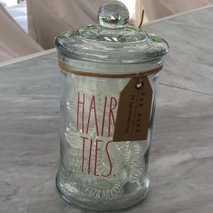 Rae dunn glass apothecary jar with 25 spiral hair ties. Pink lettering.